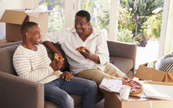 Father And Adult Son Take A Break With Pizza On Moving Day